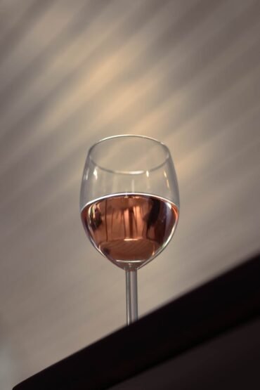 elegant wine glass with rose in soft focus