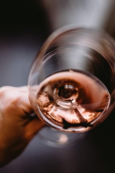 crop unrecognizable person holding glass of rose wine